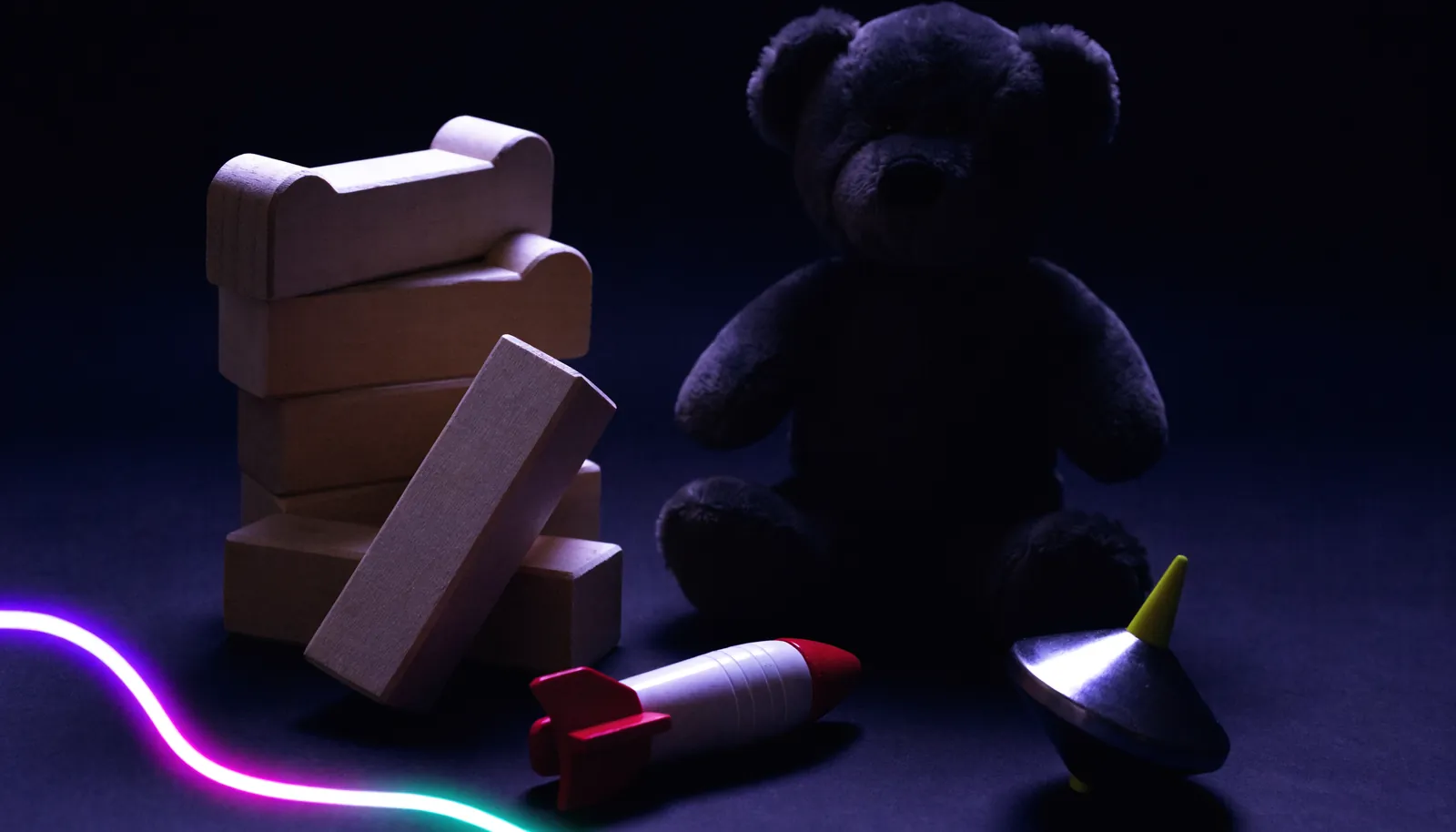 Jouets en bois et ours en peluche dans une lumière tamisée