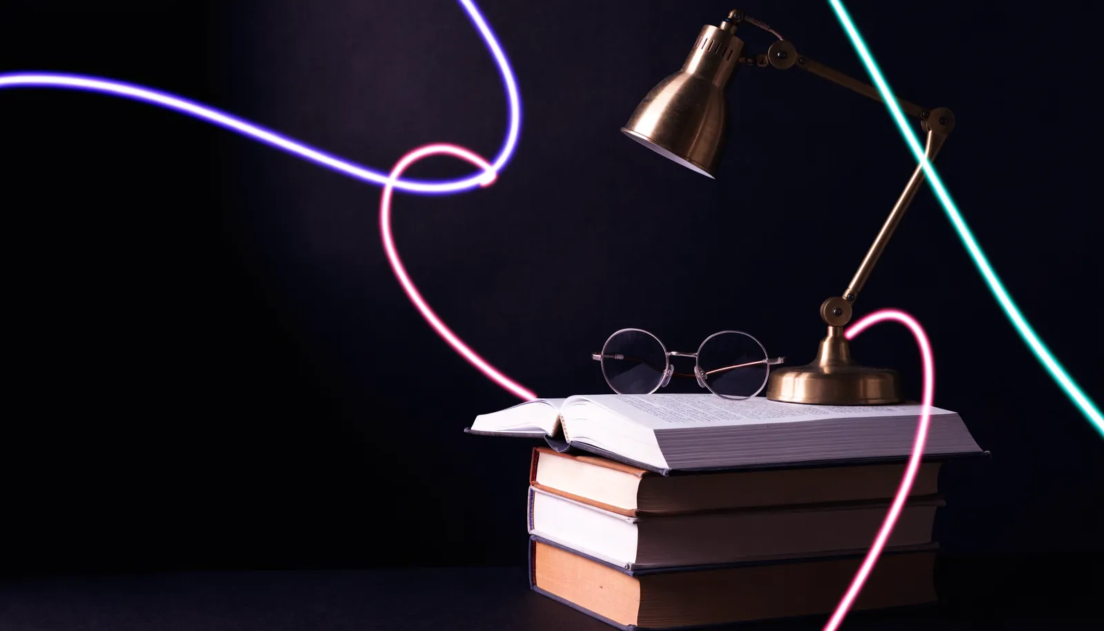 Pile de livres et lampe de lecture dans la pénombre