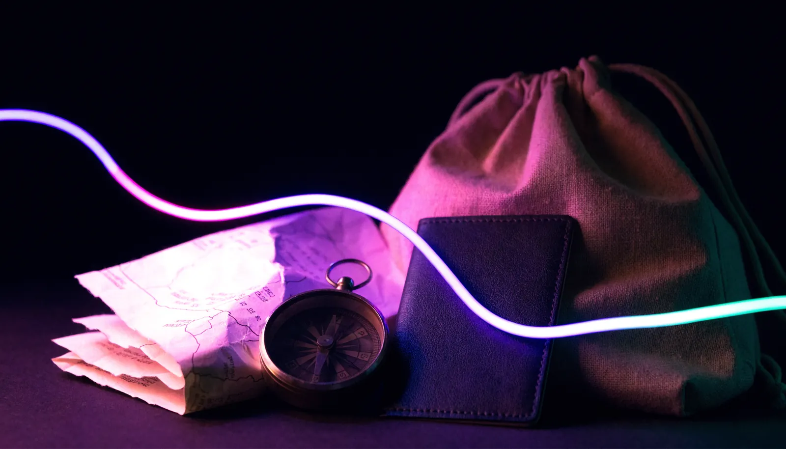 Carte, boussole et sac à dos posés sur une table sombre